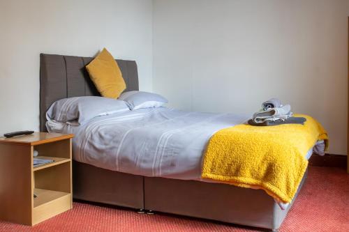 ChatterisThe George Hotel的一间卧室配有一张黄色毯子床