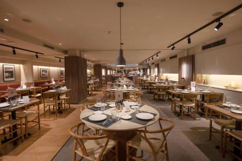 安道尔城Hotel Màgic Andorra的餐厅内带桌椅的用餐室