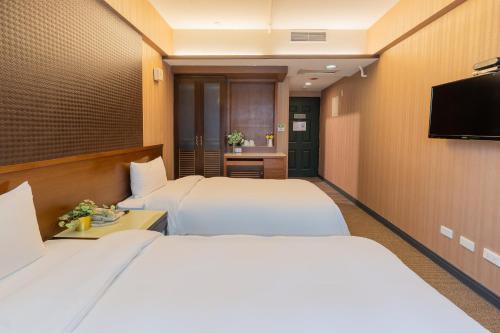 台中市雀客快捷台中逢甲的酒店客房设有两张床和一台平面电视。
