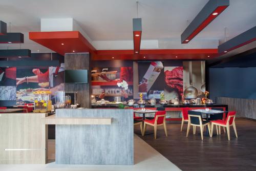 马卡萨宜必思望加锡城市中心酒店的厨房里设有桌椅的餐厅