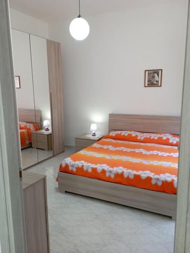 奥里斯塔诺Sardinia ovest的一间卧室配有橙色和白色床单。