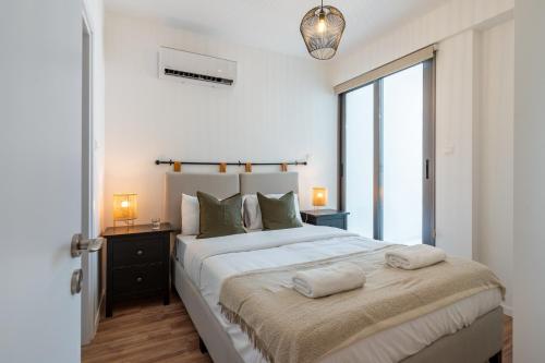 拉纳卡Latte's Prime 1-Bedroom Apartment in Larnaca的一间卧室配有一张大床和两条毛巾
