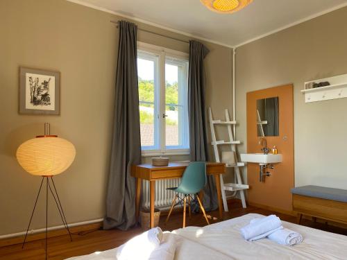 维尔茨堡Exklusives Ferienhaus in Top Lage: Der Johannishof的一间卧室配有一张床、一张书桌和一个窗户。
