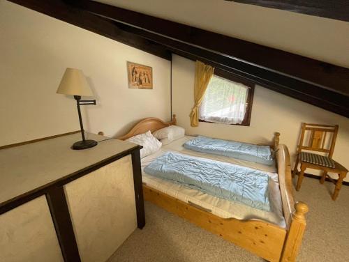 希格斯多夫Ferienwohnung Zirbelweg的一间卧室配有一张床和一张带台灯的桌子