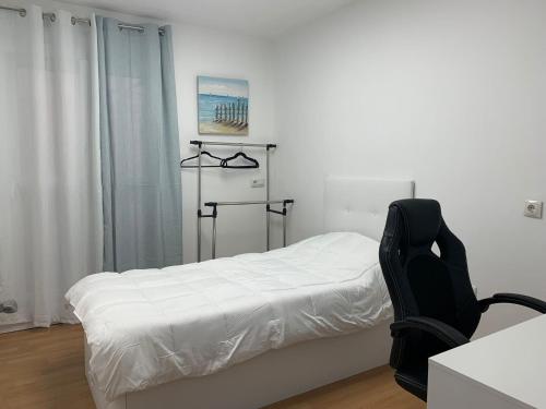 阿尔梅利马Apartamento Center Playa Almerimar的卧室配有白色的床和黑椅