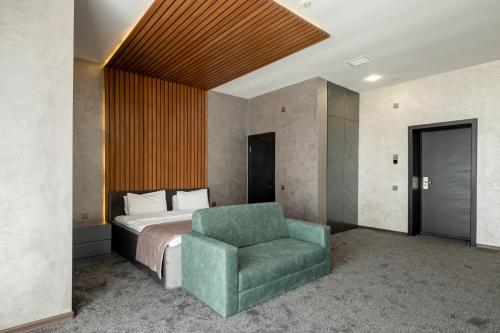 SütǝmurdovMona Hotel and Cottages的一间卧室配有一张床和一把绿色椅子