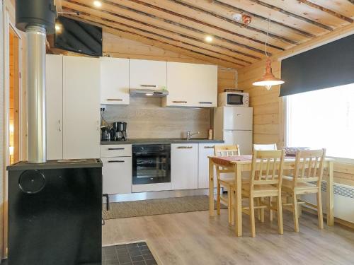 萨利色尔卡Holiday Home Poromies d by Interhome的厨房配有白色橱柜和桌椅