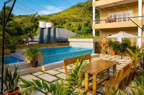 博瓦隆热带的向往公寓式酒店的一个带桌椅的庭院和一个游泳池