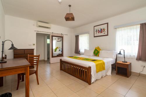 博瓦隆热带的向往公寓式酒店的一间卧室配有一张床、一张桌子和一张书桌