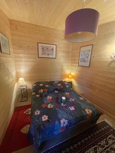 尼姆HOUDARLING Chalet avec Hammam Sauna Jacuzzi Privatif的木制客房内的一间卧室,配有一张床