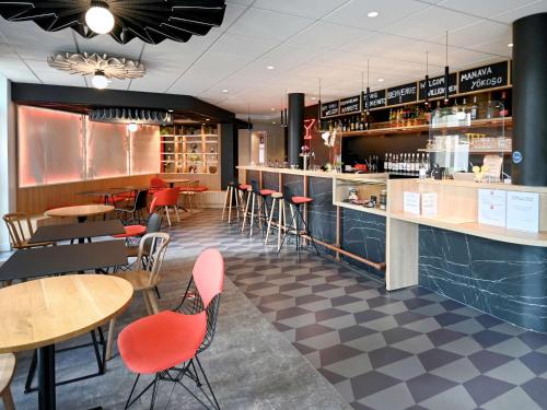 欧塞尔ibis Auxerre Centre的一间带桌椅的餐厅和一间酒吧