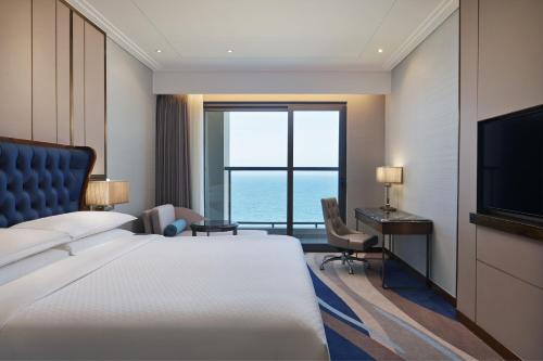 岘港岘港福朋喜来登酒店的酒店客房配有一张床、一张书桌和一台电视。