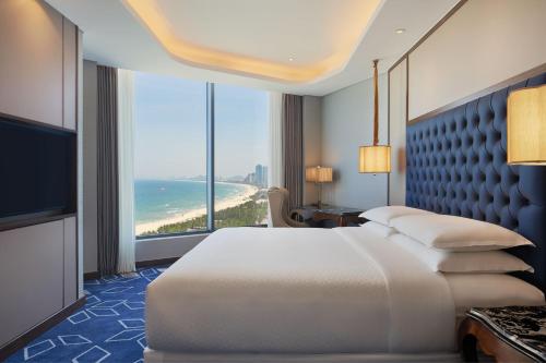 岘港岘港福朋喜来登酒店的一间卧室配有一张床,享有海景
