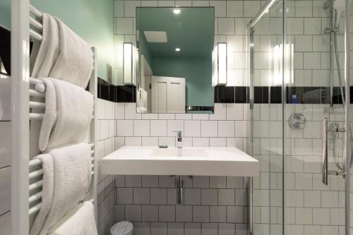 都柏林永利酒店的白色的浴室设有水槽和镜子