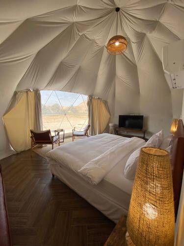 Al Fawwāzمنتجع جلامبنغ - Glamping Resort的帐篷内一间卧室,配有一张床