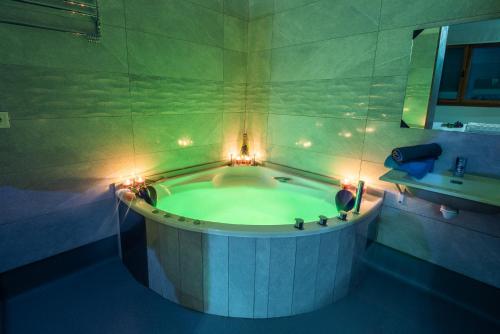 奥维多Apartamentos Spa Las Caldas y Spa El Balneario的浴室配有带灯的浴缸。