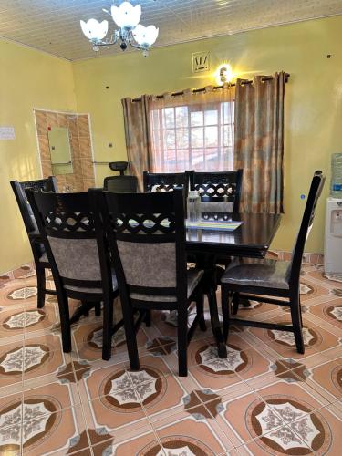MaralalLoresho cottages的一间用餐室,配有黑色的桌子和椅子