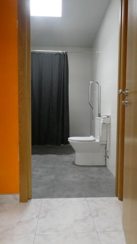 帕德隆Albergue cafetería Río Sar的一间带卫生间和黑色淋浴的浴室