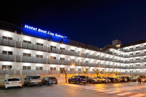 萨洛萨鲁卡普最佳酒店的停车场内停放汽车的大型建筑