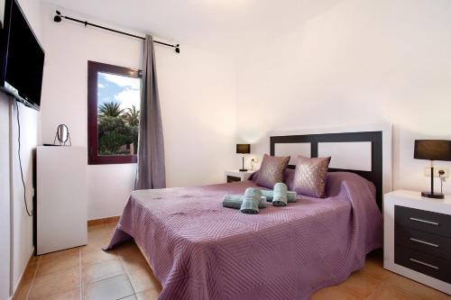 科拉雷侯Villa Malva的一间卧室配有一张紫色床,上面有两只泰迪熊