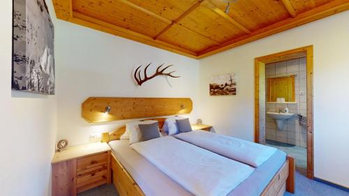 瓦德林Chalet Tirol Waidring的一间卧室设有一张大床和一个水槽