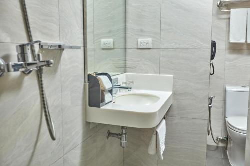 马尼拉Belmont Hotel Manila的一间带水槽和卫生间的浴室