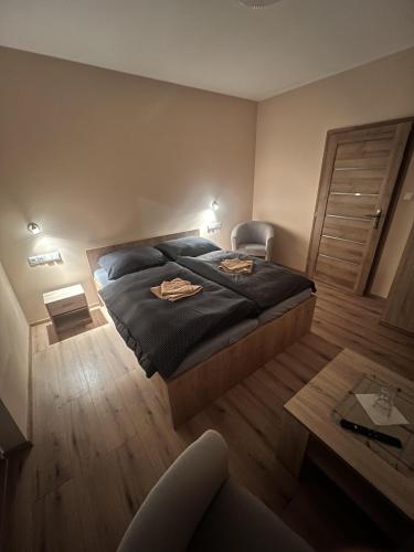 胡门内Penzion u Tučňaka的卧室配有1张床、1张桌子和1把椅子