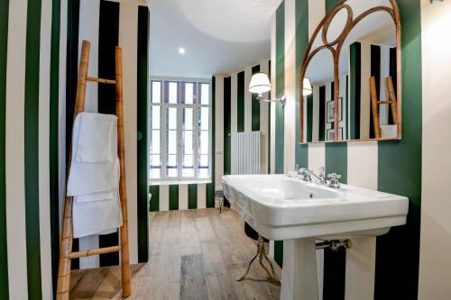 布鲁纳特Relais Villino Rubini的浴室设有白色水槽和绿色及白色条纹