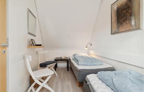 阿灵厄Amazing Apartment In Allinge With Wifi的配有椅子和桌子的客房内的两张床