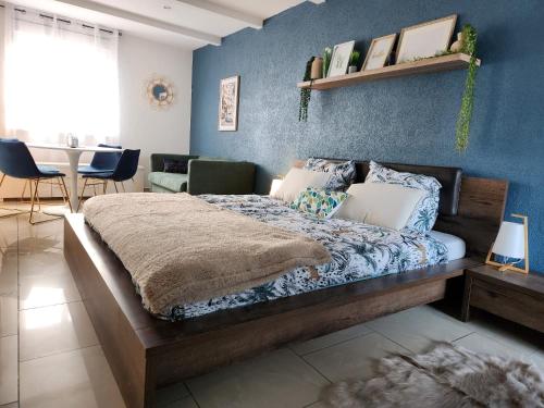 圣路易Suite 2 lits Auberge du Manala Hôtel 24 24 proche Basel的一间卧室配有一张蓝色墙壁的床