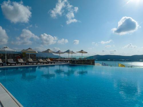 伊罗达Royal Marmin Bay Boutique & Art Hotel的一个带椅子和遮阳伞的大型游泳池