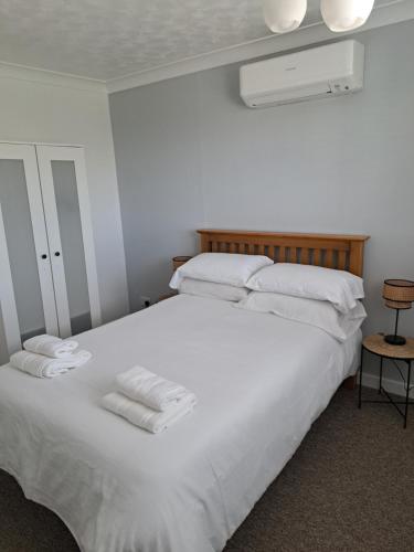 RamseyExtensive 4 bed close to Peterborough的卧室配有带毛巾的大型白色床