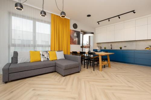 华沙Cozy & Spacious Family Apartment by Renters的客厅以及带沙发和桌子的厨房。