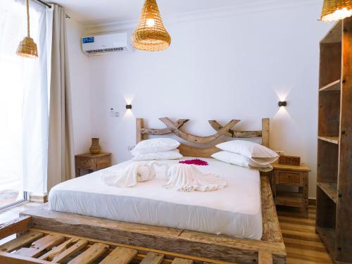 南威Limiria Villa Zanzibar的卧室配有白色的床和木制床头板