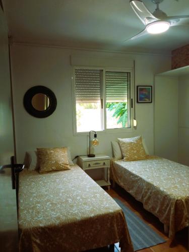 AlberiqueLas Palmeras的一间卧室设有两张床和窗户。