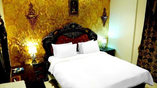 科威特Hotel Leaders Plaza Mahboula的一间卧室配有一张红色床头板的床