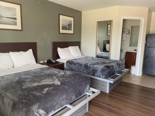 帕里斯Paris Extended Stay Suites的酒店客房,设有两张床和镜子