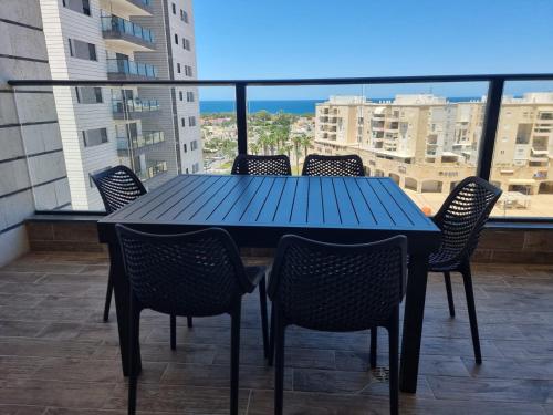阿卡Apartment in Akko with Sea View的阳台上配有蓝色的桌椅