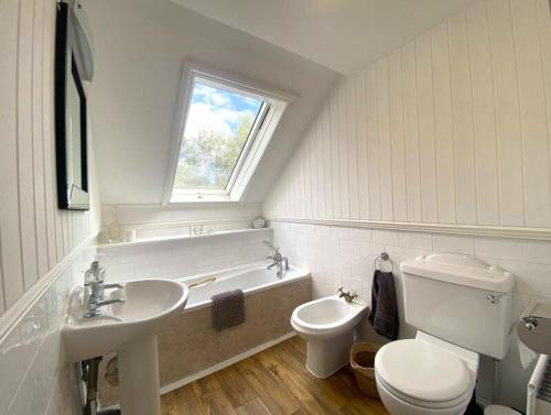 莫珀斯Morpeth town centre - Cottingburn House的浴室配有盥洗盆、卫生间和浴缸。