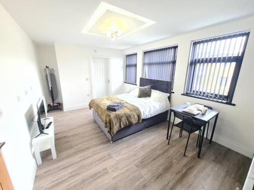 Batley CarrHomestay by BIC Legends 2的卧室配有床、桌子和窗户。