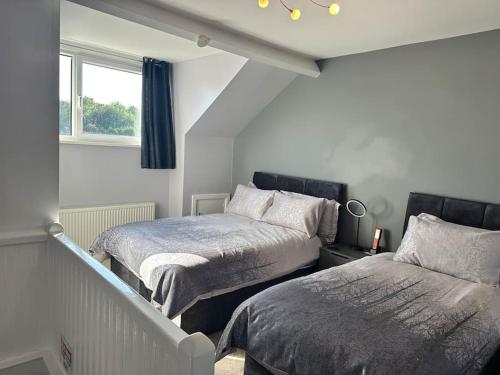 武姆韦尔Spacious 3 bed house in Wombwell的一间卧室设有两张床和窗户。
