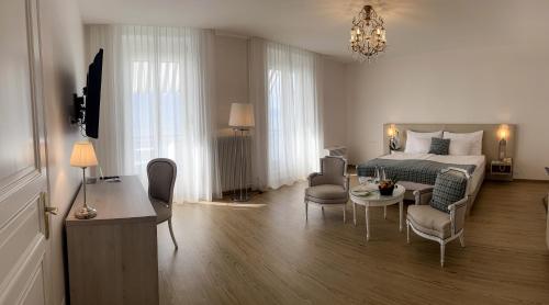 蒙特勒伊甸园宫奥拉克酒店的卧室配有一张床和一张桌子及椅子