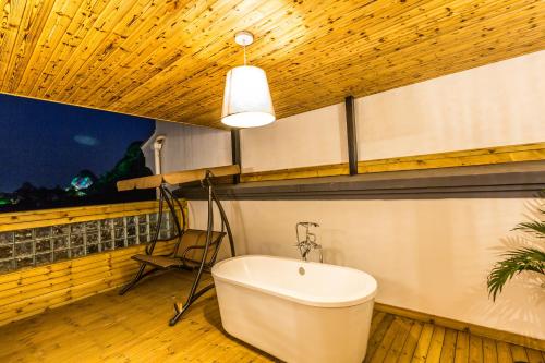 桂林明月芦花度假酒店的带浴缸、椅子和窗户的浴室