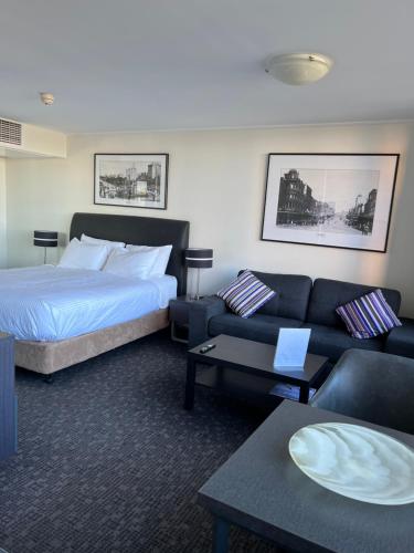 悉尼Prestige Hyde Park Studio Apartment的酒店客房,配有床和沙发