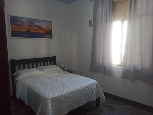 圣保罗Apto Centro SP ótima localização的一间卧室配有一张带白色毯子的床和窗户。