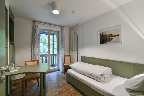 文西德尔Luisenburg Resort的一间卧室配有一张床、一张桌子和一张桌子
