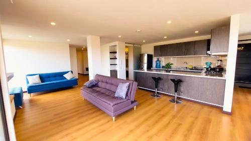 MosqueraLa Isabella Deluxe的一间带紫色沙发的客厅和一间厨房