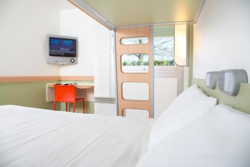 蒙德维尔宜必思卡恩蒙德维尔经济酒店的一间卧室配有一张床、一张桌子和一台电视。