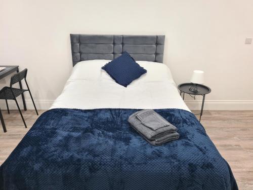 Batley CarrHomestay by BIC Legends 5的一张带蓝色棉被和蓝色毯子的床