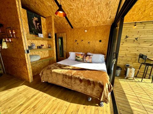 里奥内格罗Caralsol Glamping的木制客房内的一间卧室,配有一张床